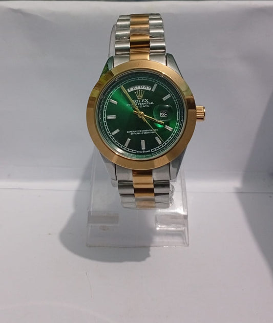 Two-tone gold and silver watch with a green face on a white background