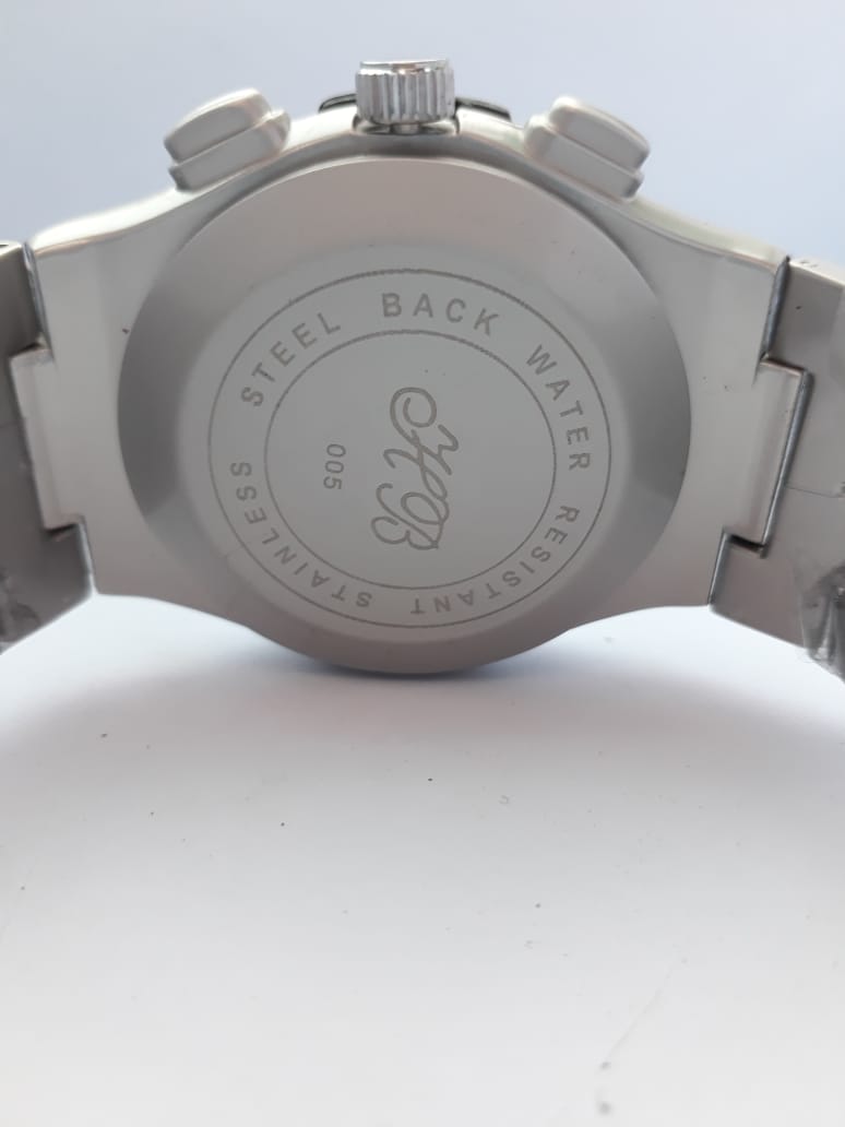 Close-up of a silver watch back with branding on a white background