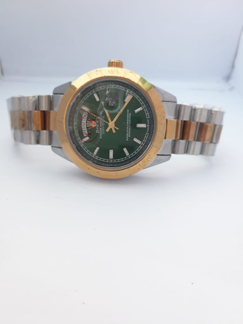Two-tone watch with green dial on a white background